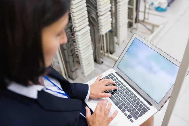 Attentive technician using laptop in server room