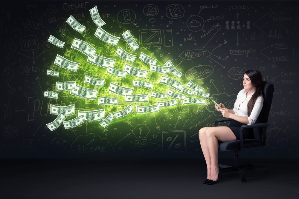 Businesswoman sitting in chair holding tablet with dollar bills coming out concept on background
