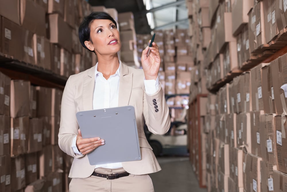 Warehouse manager checking her inventory in a large warehouse