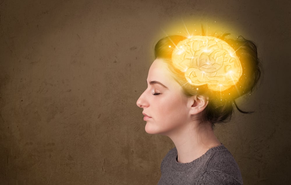 Young girl thinking with glowing brain illustration on grungy background